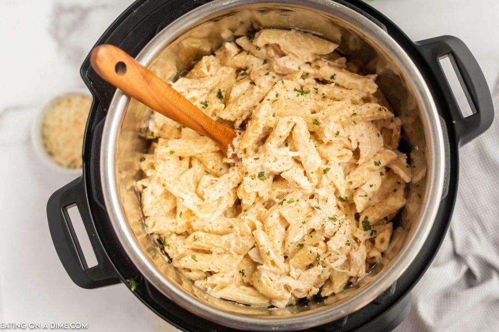 Creamy Cajun Chicken Pasta in the Instant Pot with a wooden spoon