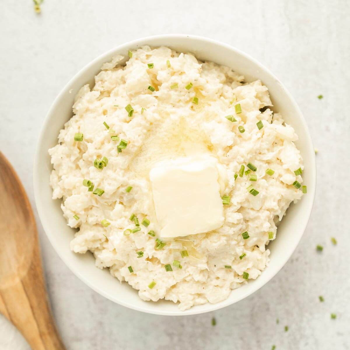 Close up image of mashed cauliflower with butter on top in a bowl