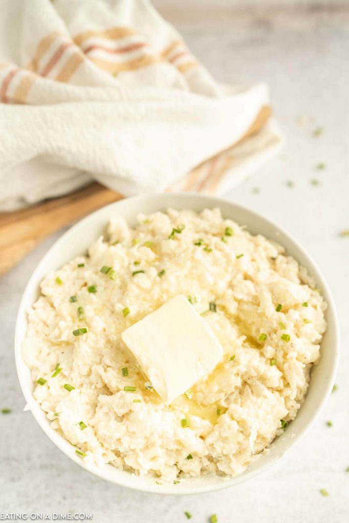 Close up image of mashed cauliflower with butter on top in a bowl