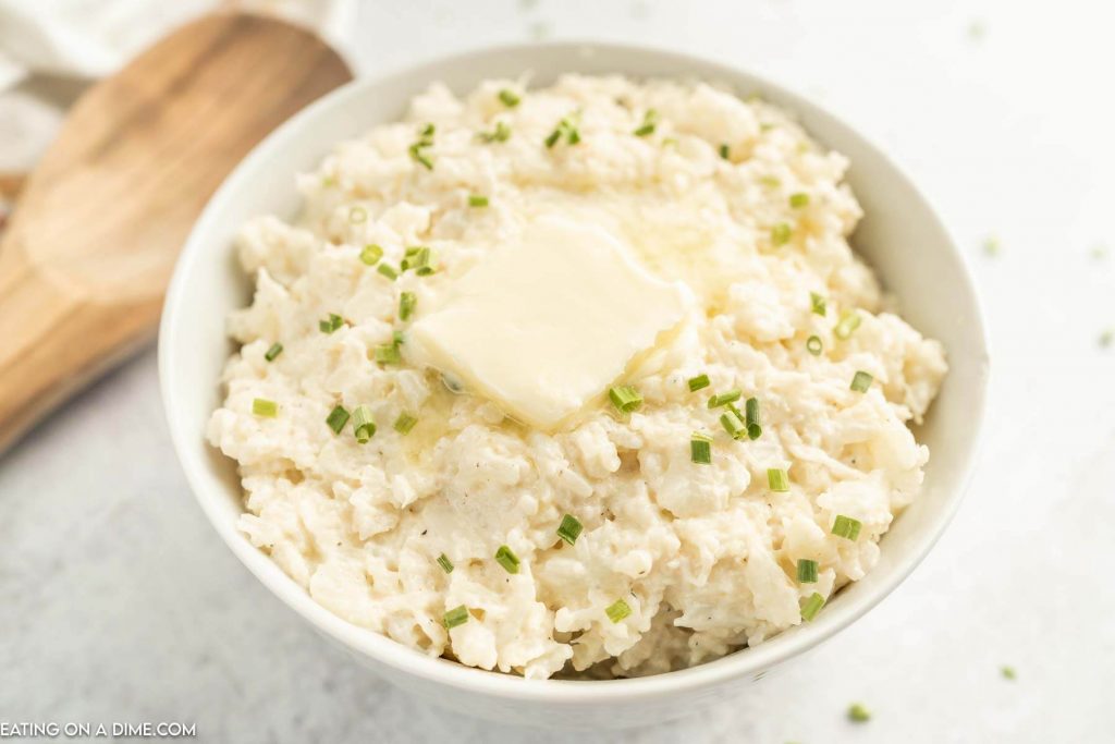 Close up image of mashed cauliflower with butter on top in a bowl 