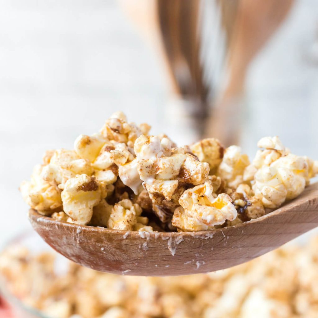 Cinnamon roll Popcorn on a wooden spoon