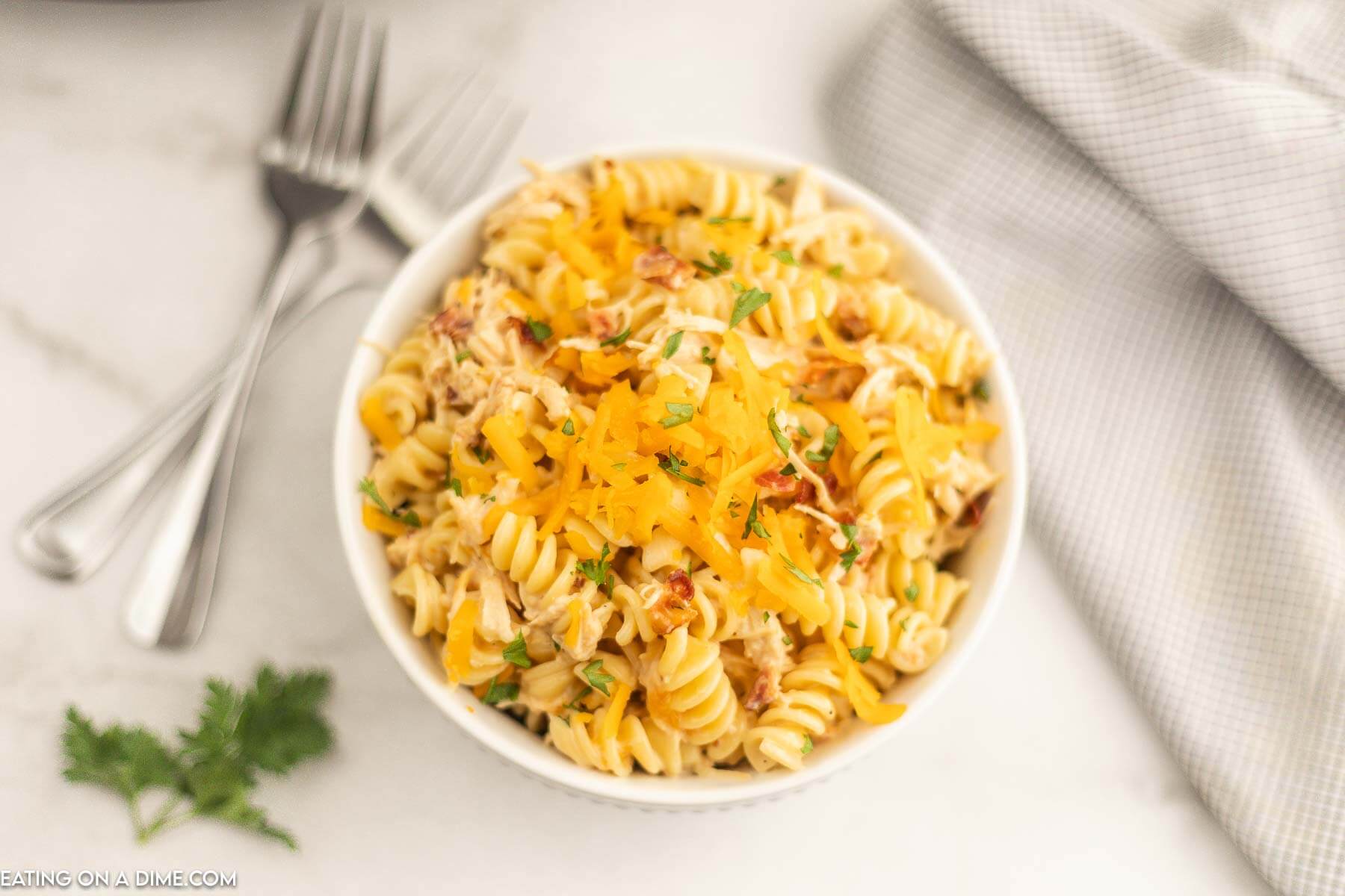 Chicken bacon ranch pasta in a bowl topped with cheddar cheese