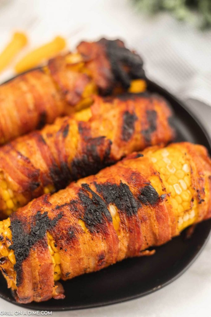 bacon wrapped corn on the cob on plate