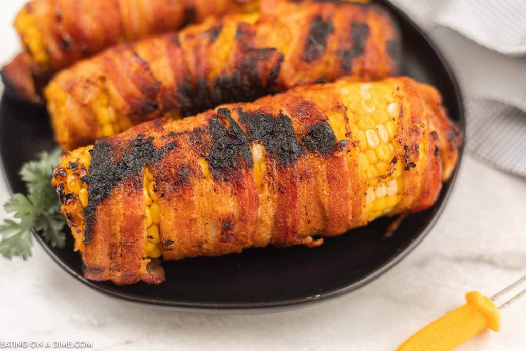 bacon wrapped corn on the cob on plate
