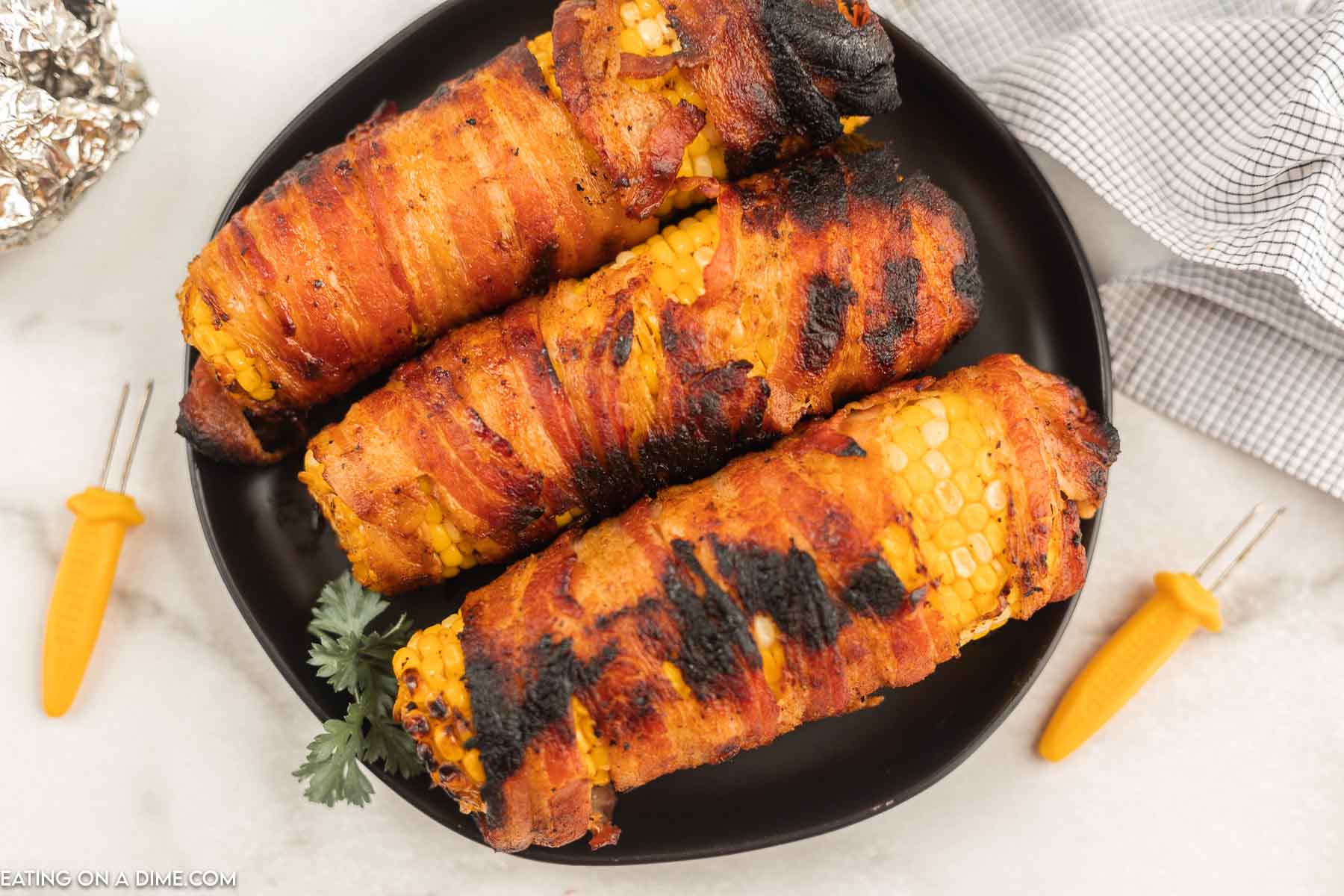 bacon wrapped corn on the cob on plate