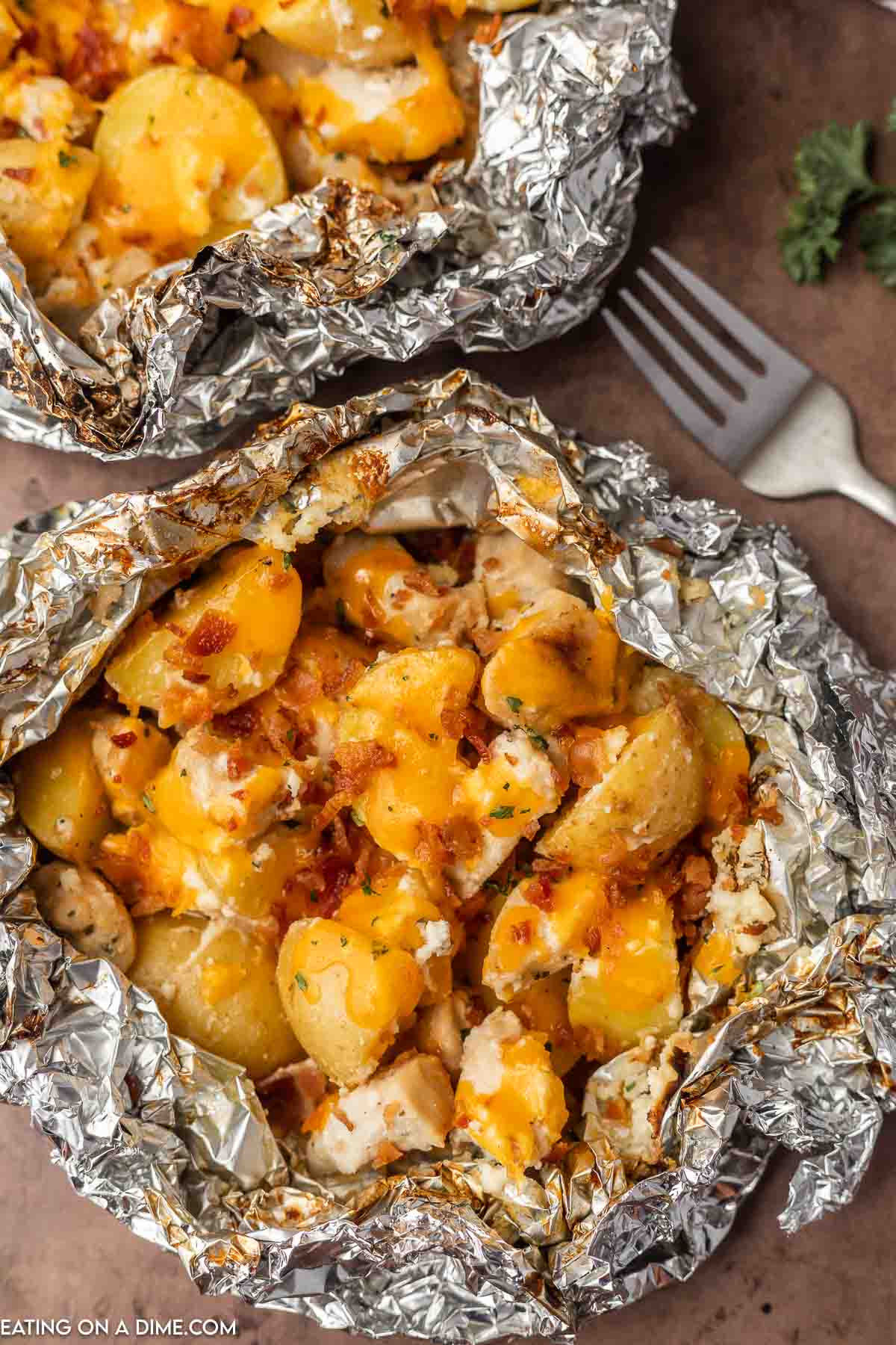 Cooked crack chicken topped with melted cheese on a piece of foil