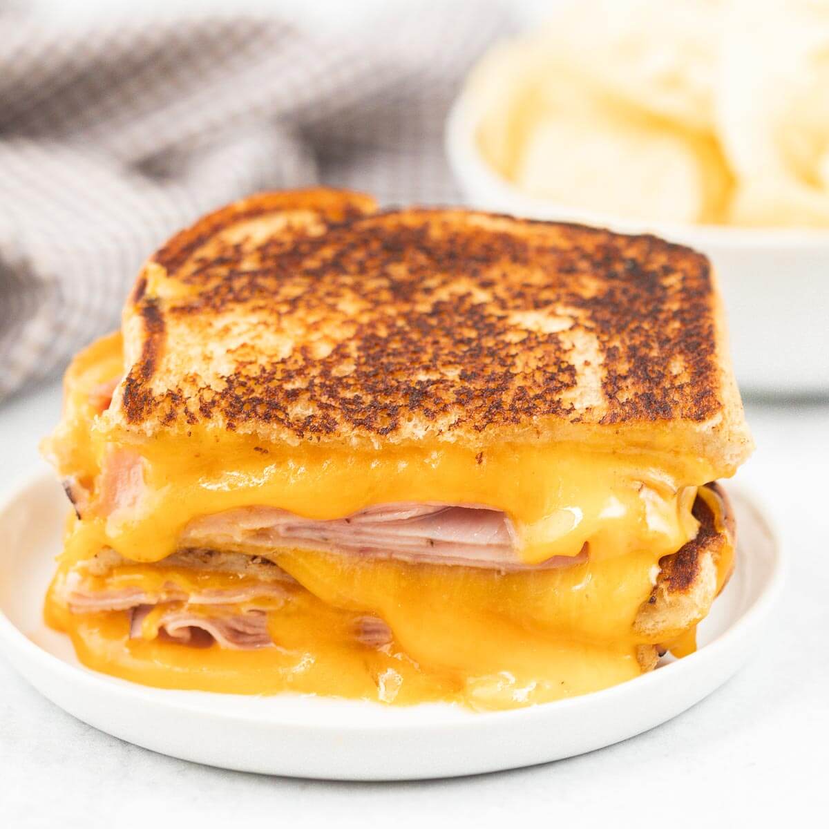 Grilled ham and cheese sandwich on a plate. 