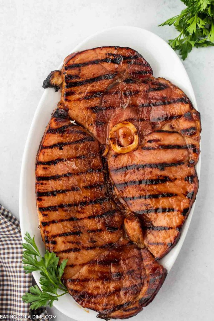 Grilled ham steak on a white plate. 