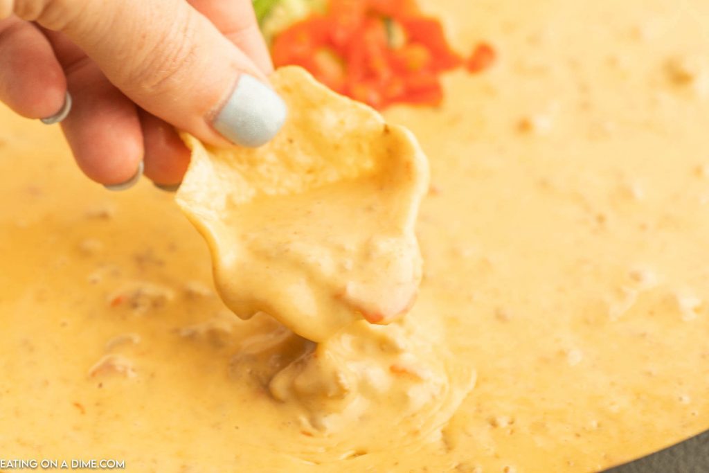Close up image of dipping a chip in the rotel dip