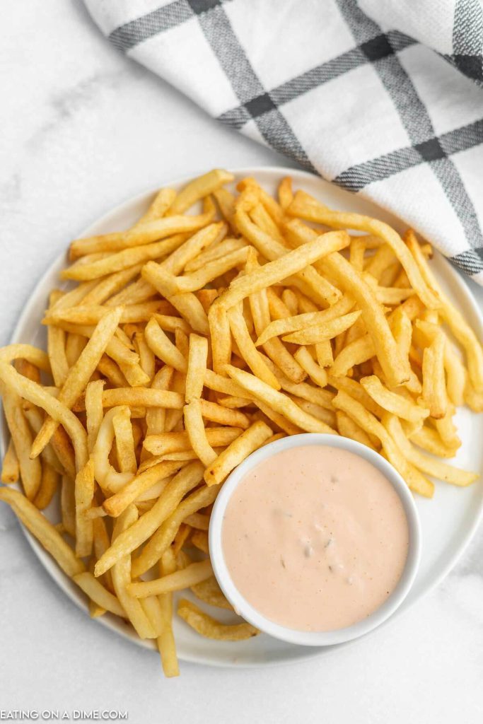 Close up image of dipping sauce with a plate of fries