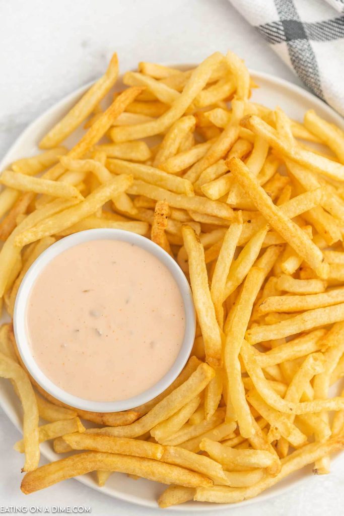 Close up image of dipping sauce with a plate of fries
