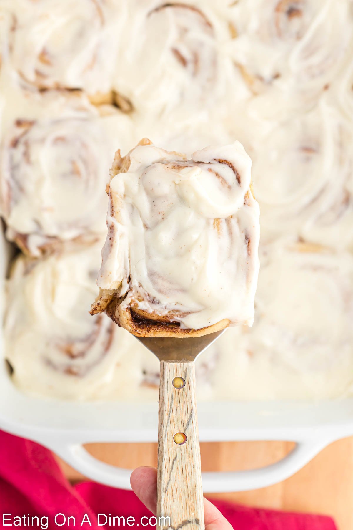 Cinnamon Rolls in a pan with a serving on a spatula