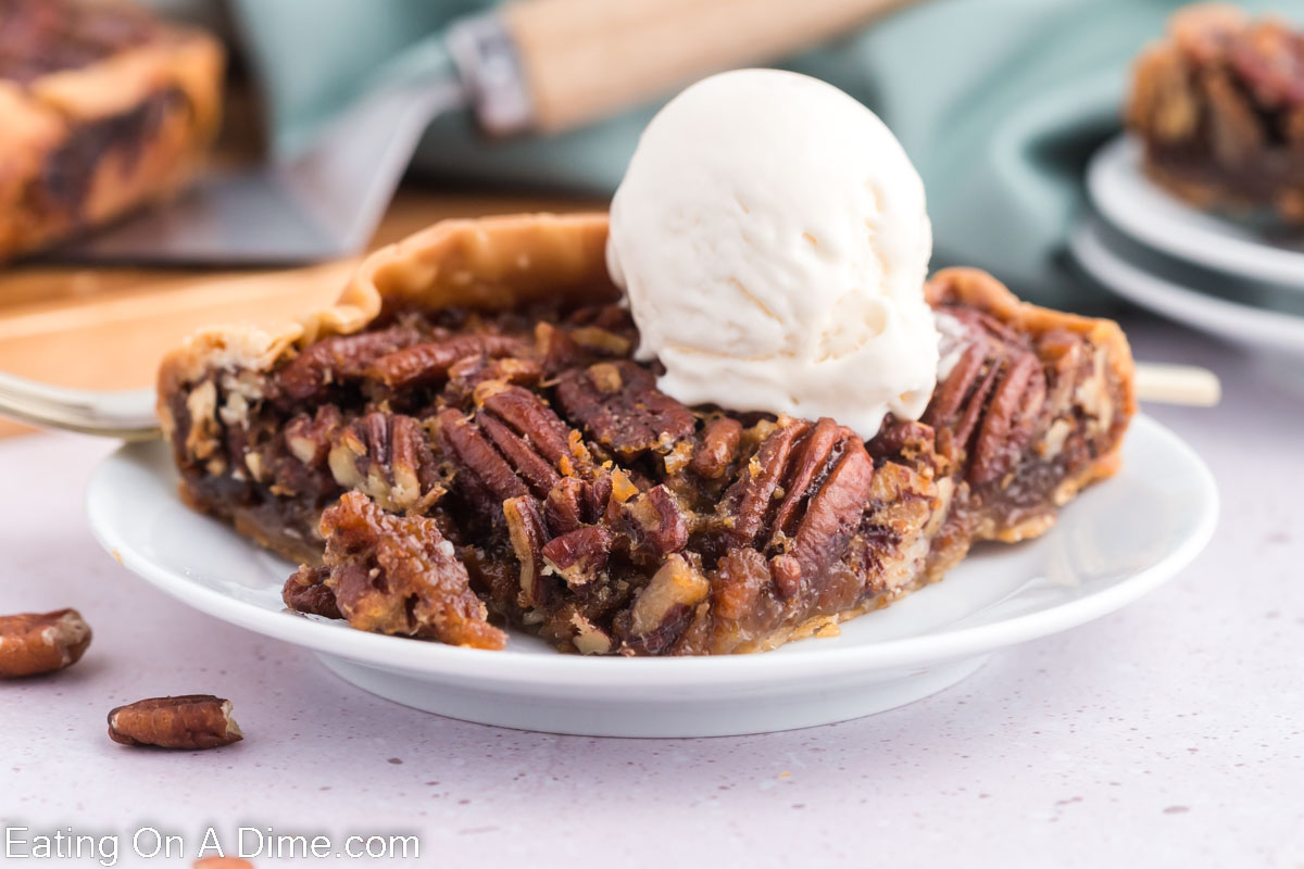 Slice of Pecan Pie on a white plate with a scoop of ice cream