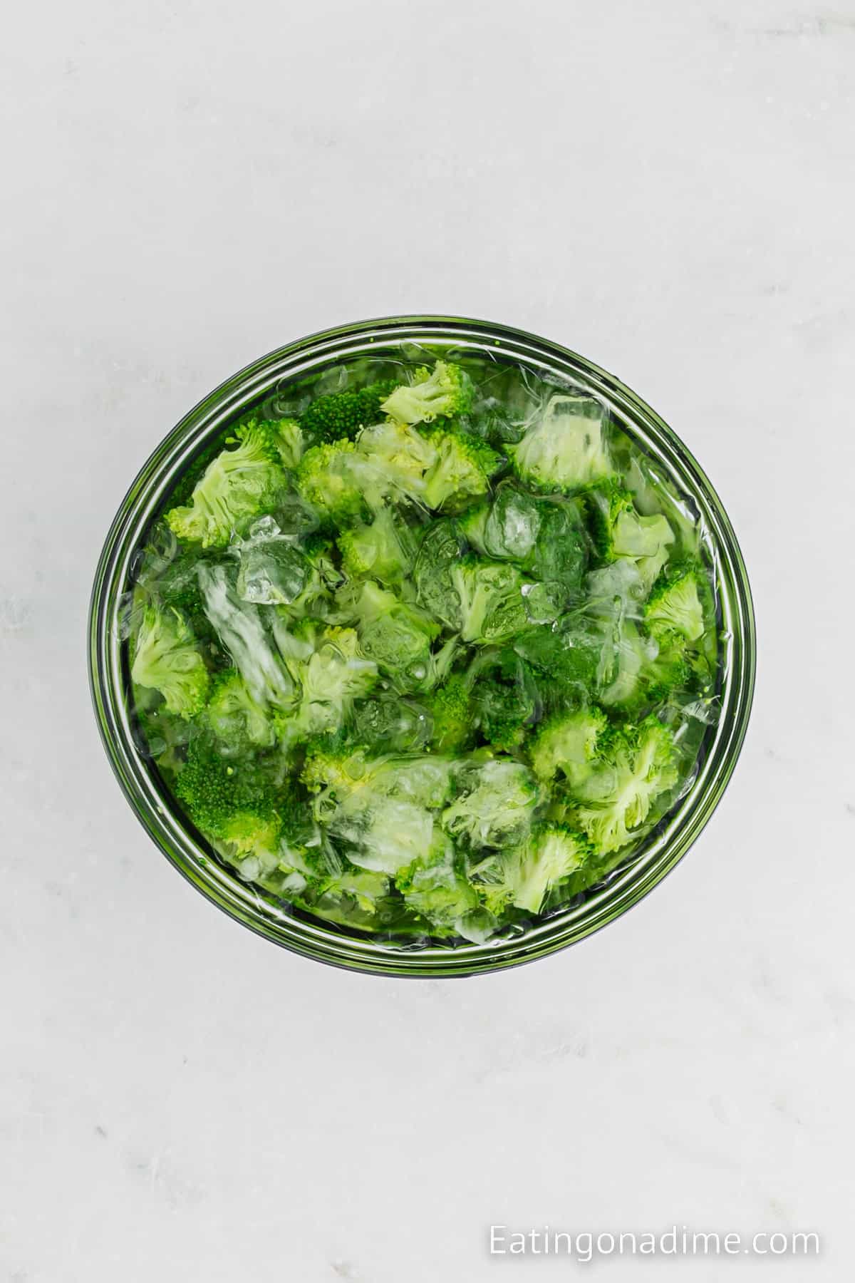 Broccoli in a large pot with ice and cold water.