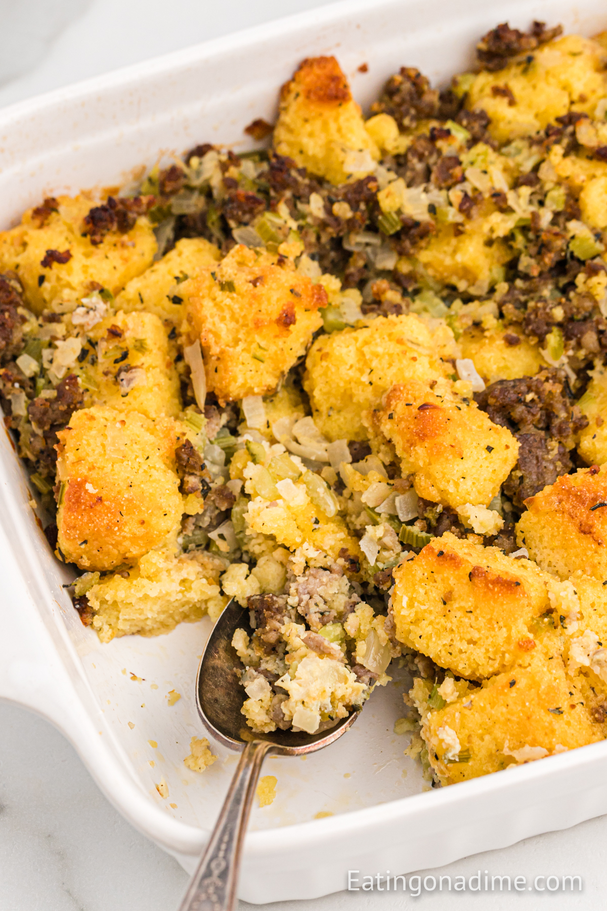 Cornbread Sausage Stuffing in a baking dish with a spoon
