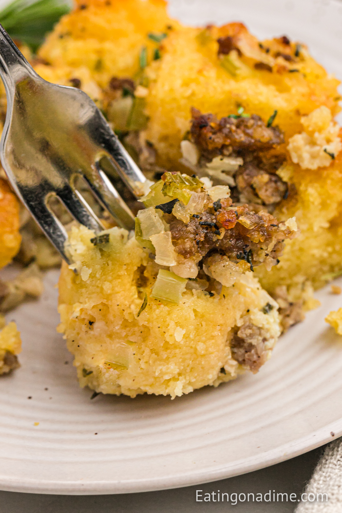Cornbread Sausage Stuffing on a plate with a bite on a fork