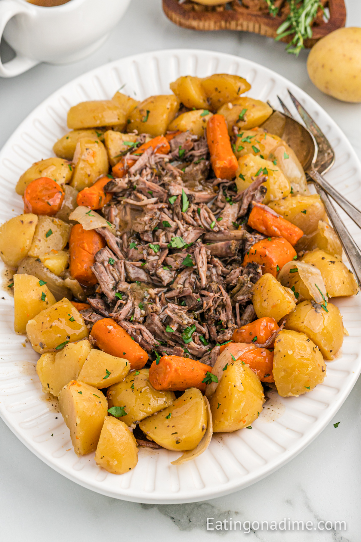 Shred Pot Roast on a platter with potatoes and carrots