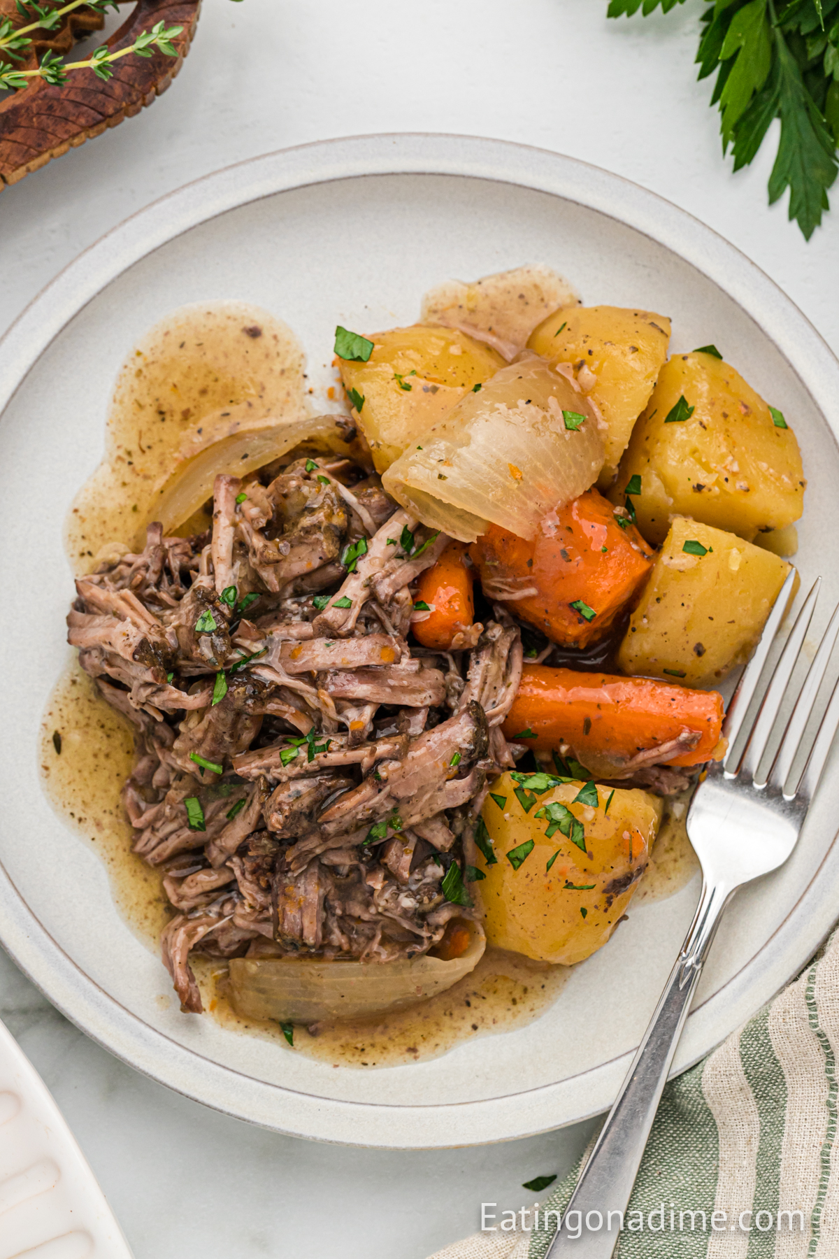 Shred Pot Roast on a plate with potatoes and carrots