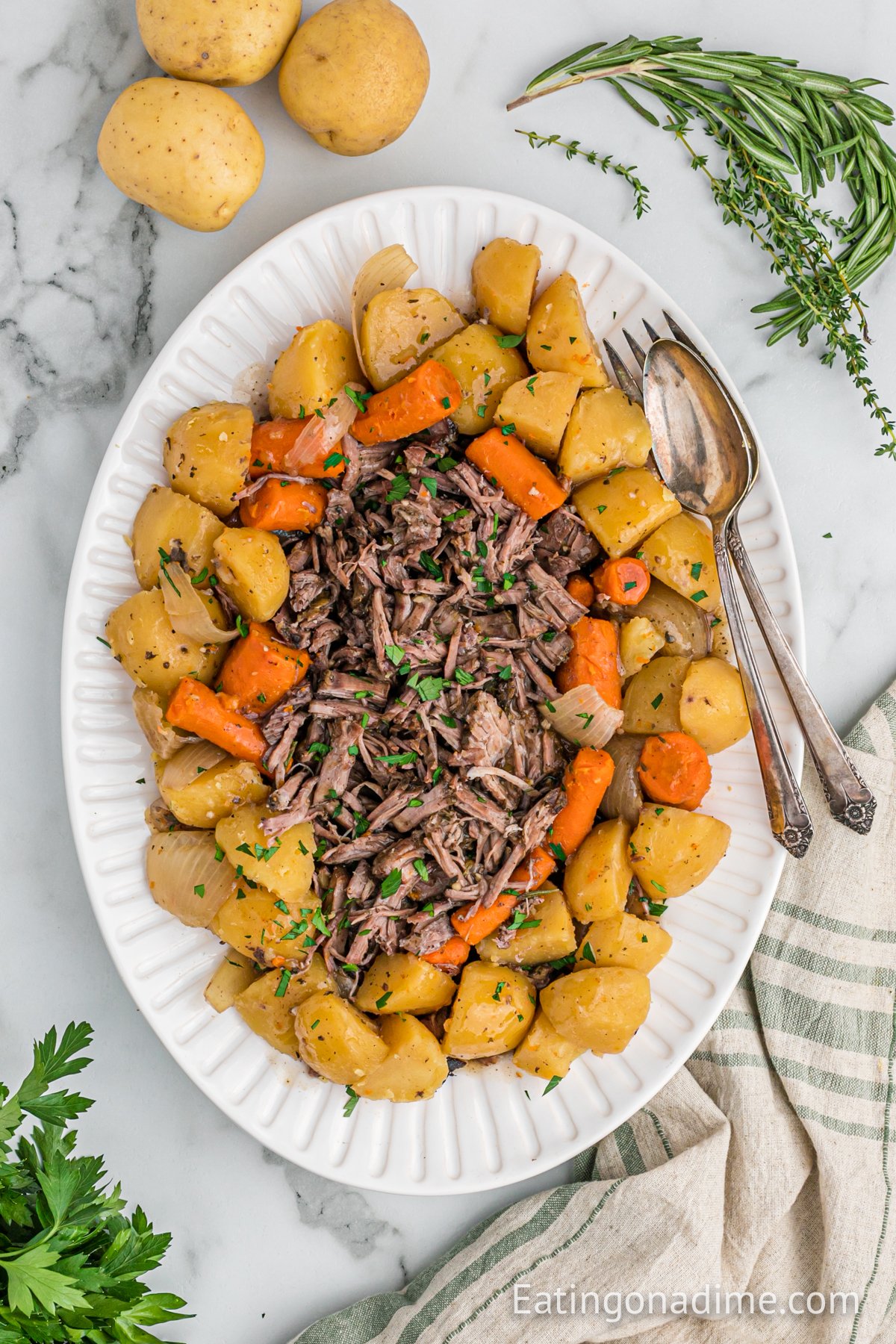 Shred Pot Roast on a platter with potatoes and carrots