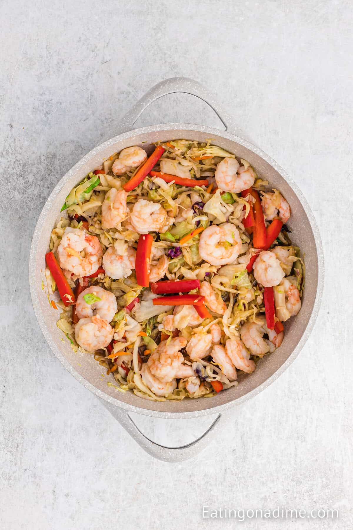 Shrimp added to the cooked vegetable mixture in a large skillet.