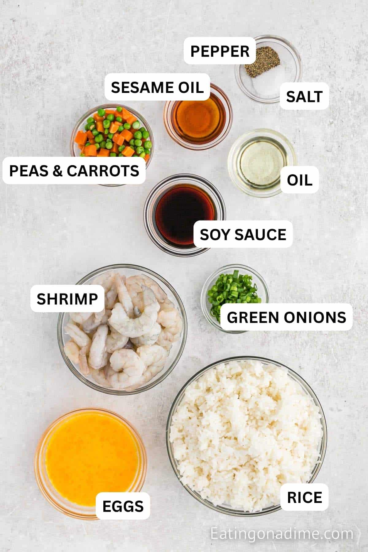 Ingredients needed for this recipe includes shrimp, eggs, sesame oil, vegetable oil, rice, soy sauce, salt and pepper, peas and diced carrots, green onions.
