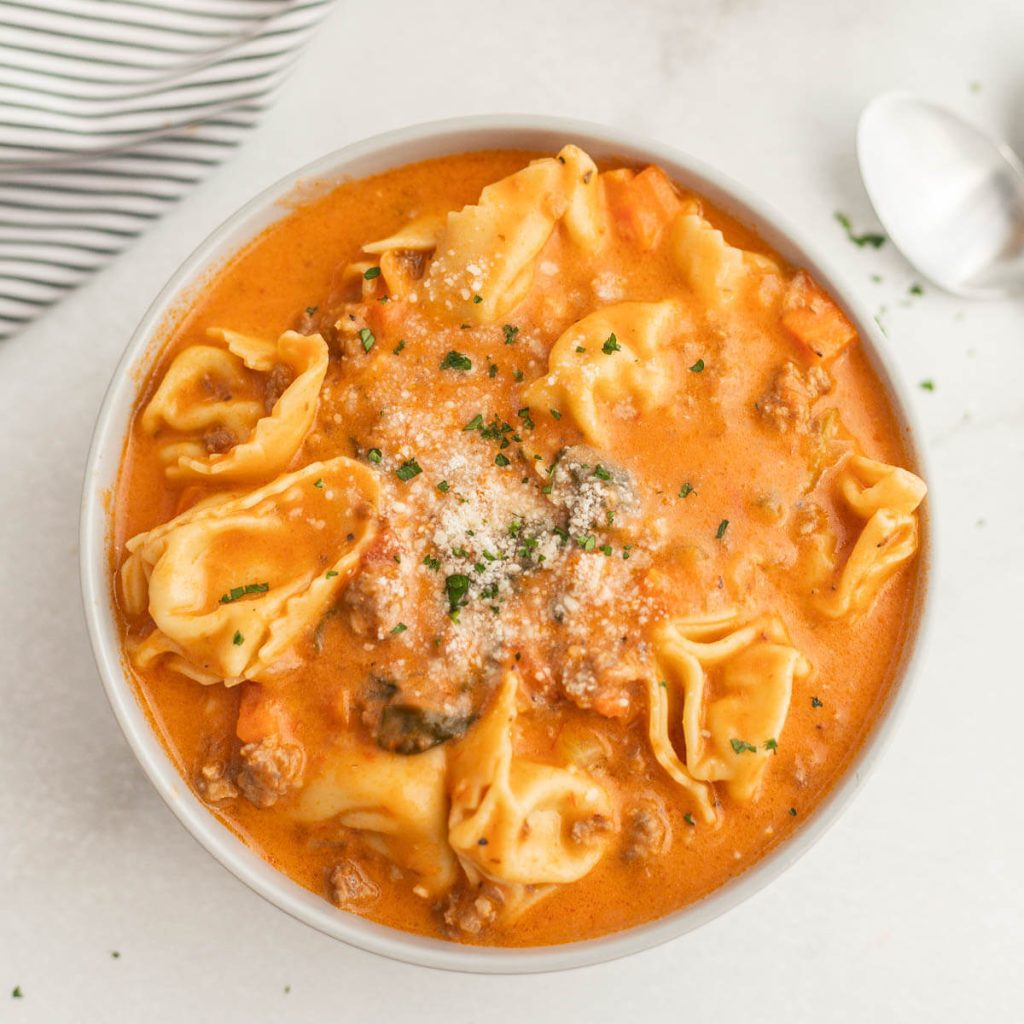 Close up image of creamy sausage tortellini soup in a bowl