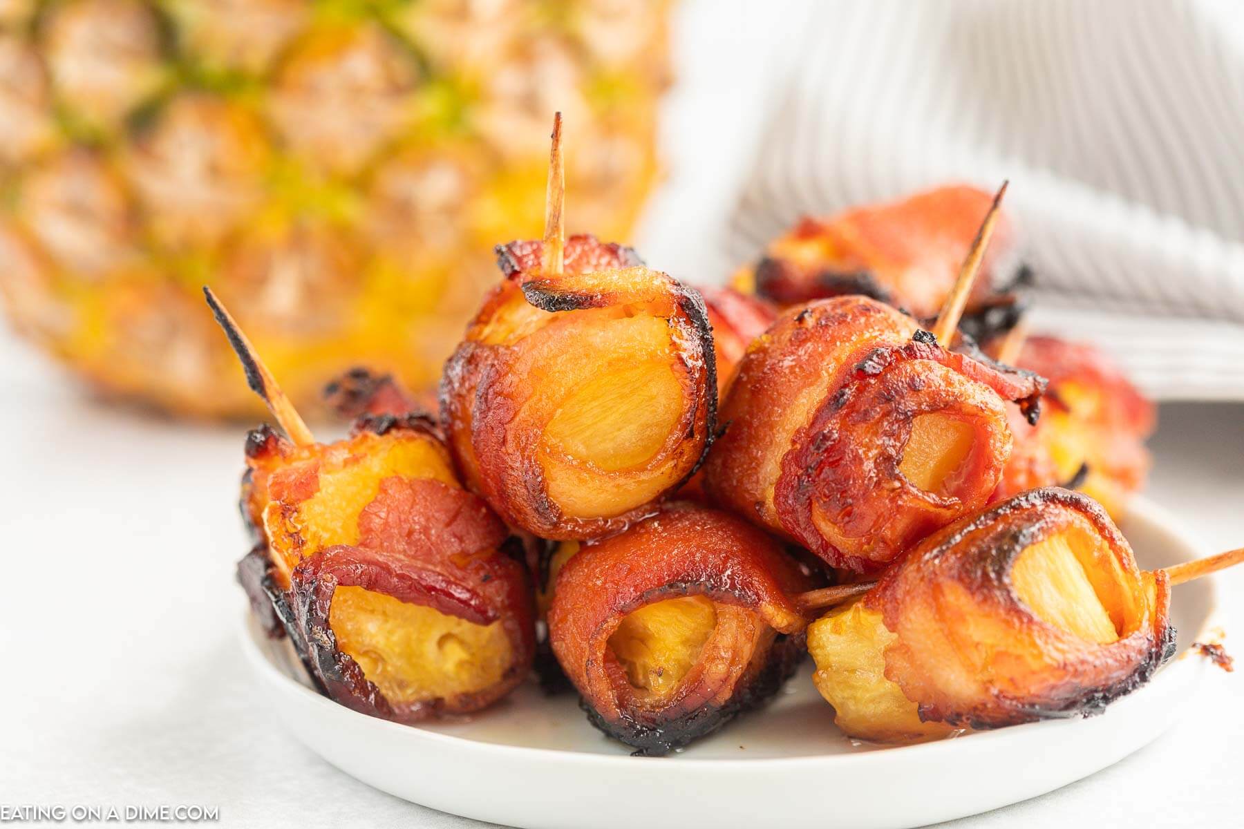 Bacon Wrapped Pineapple Bites on a white plate
