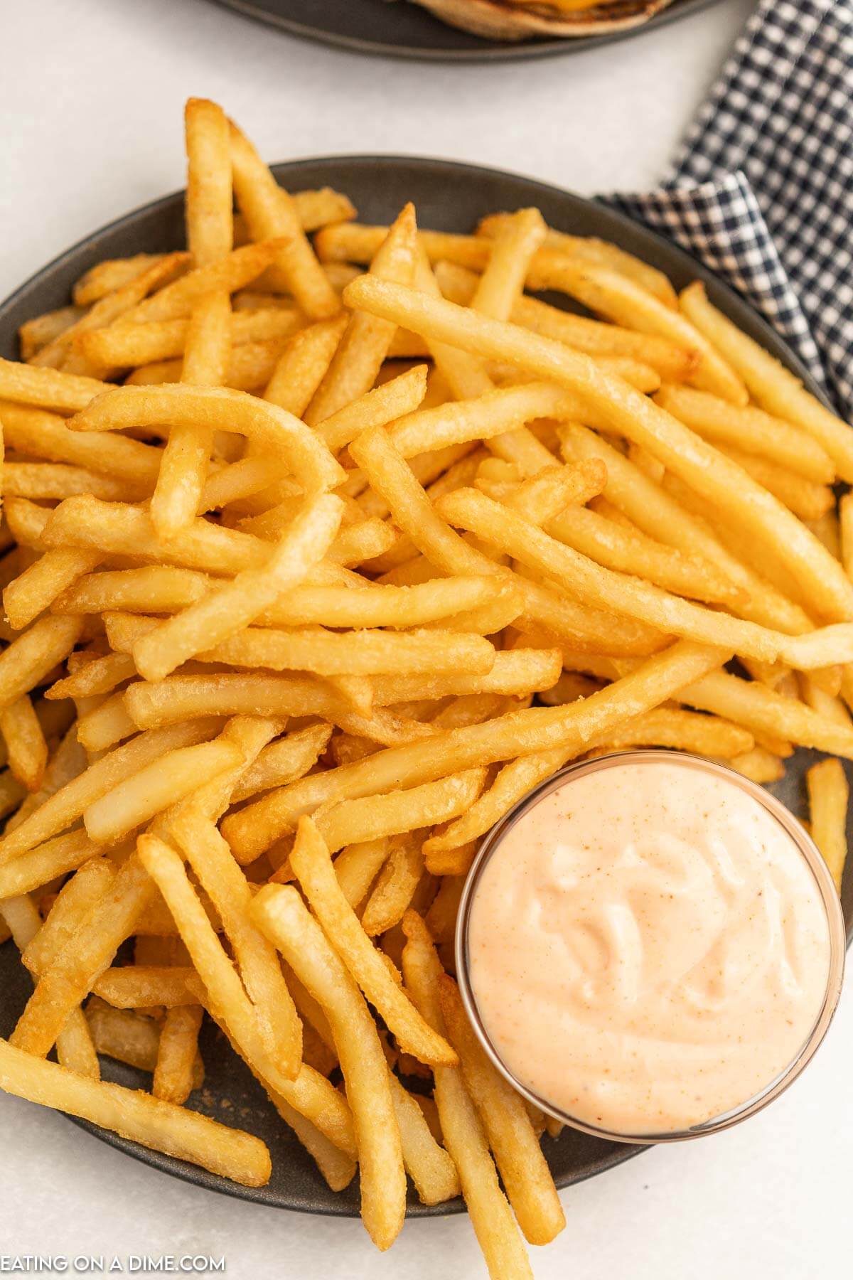 Plate of french fries with a side of sauce