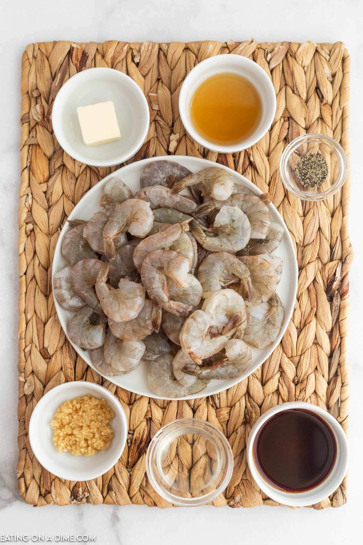 Hibachi shrimp ingredients ready to cook - raw shrimp, butter, minced garlic, sesame oil, soy sauce, mirin, pepper
