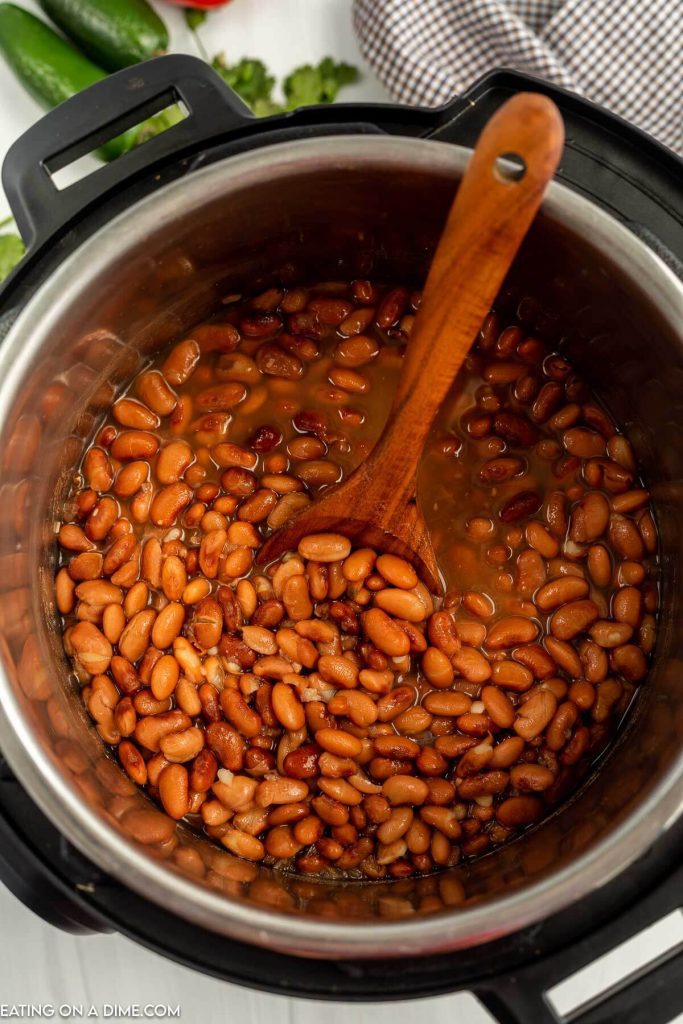 Pinto Beans in the instant pot with a wooden spoon