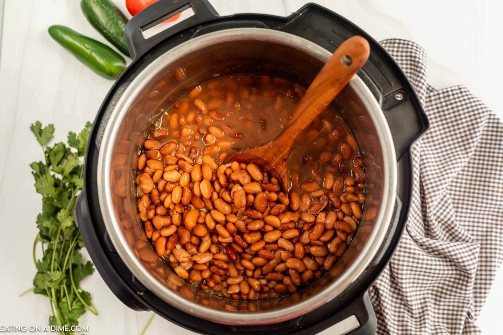 Pinto Beans in the instant pot with a wooden spoon