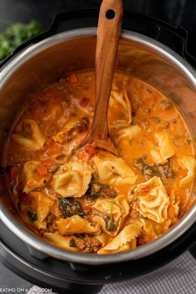Tortellini Soup in the instant pot with a wooden spoon