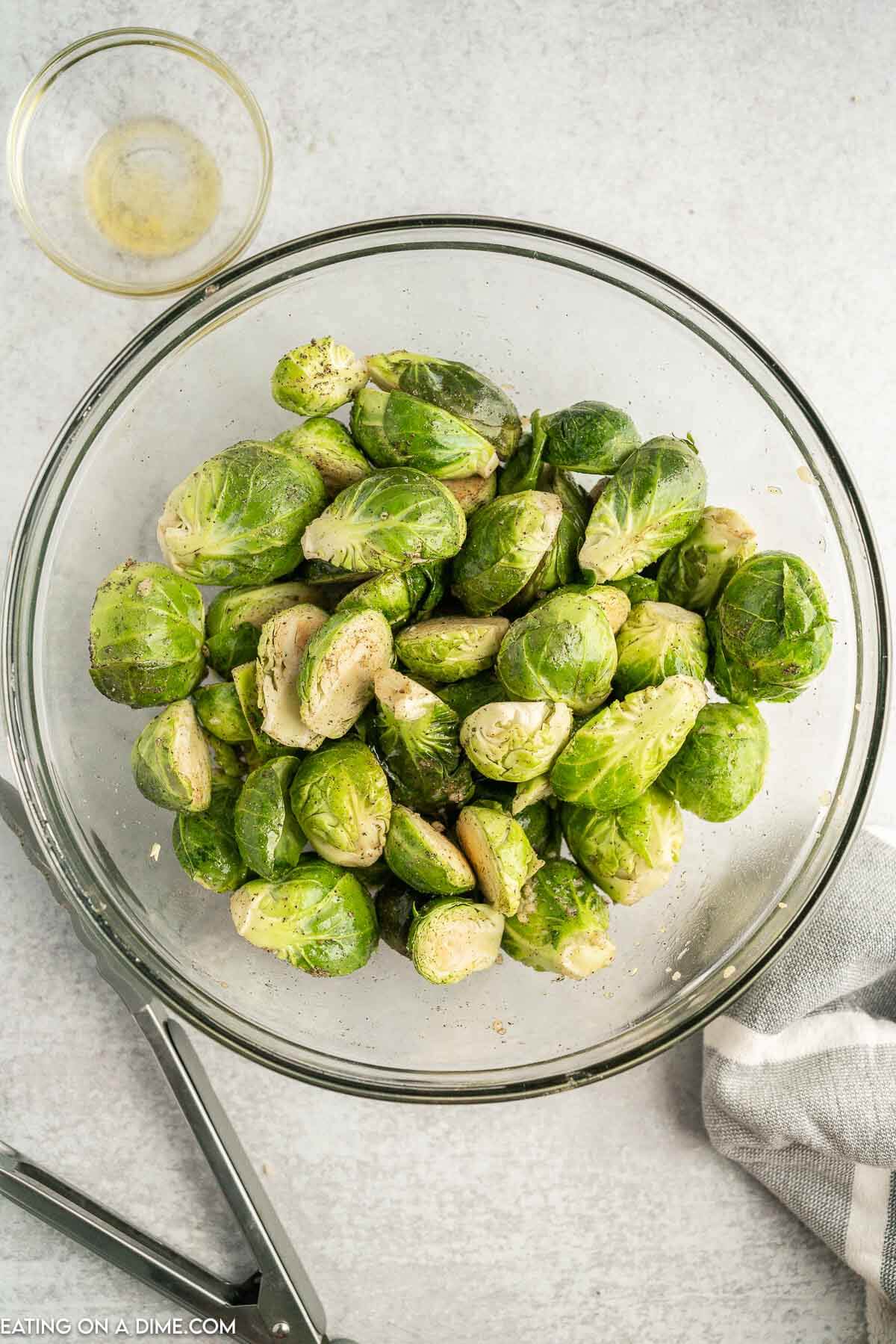 Mixing the brussel sprouts in a bowl with seasoning