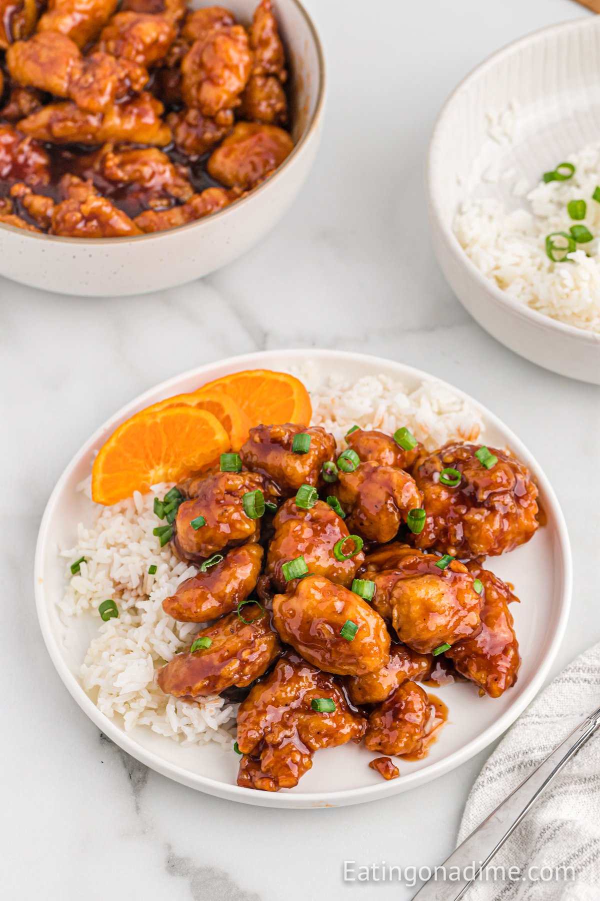 Orange Chicken on a plate with white rice and a fork
