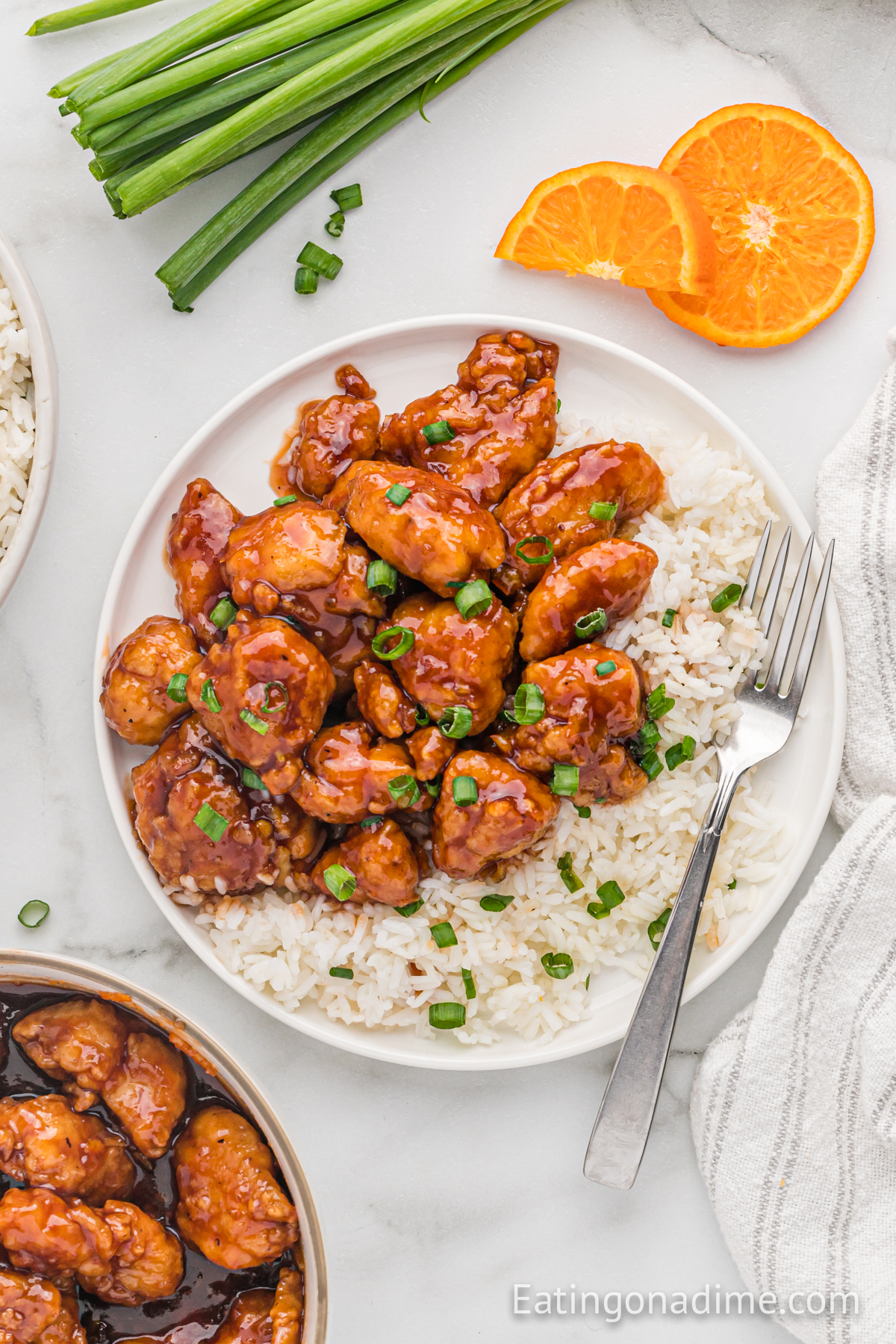 Orange Chicken on a plate with white rice and a fork