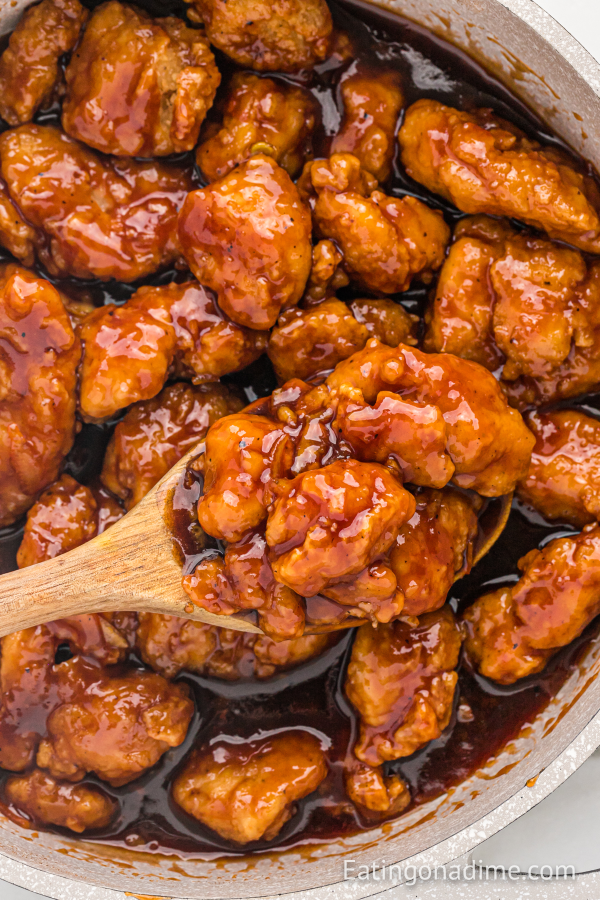 Orange Chicken in a Skillet with a wooden spoon