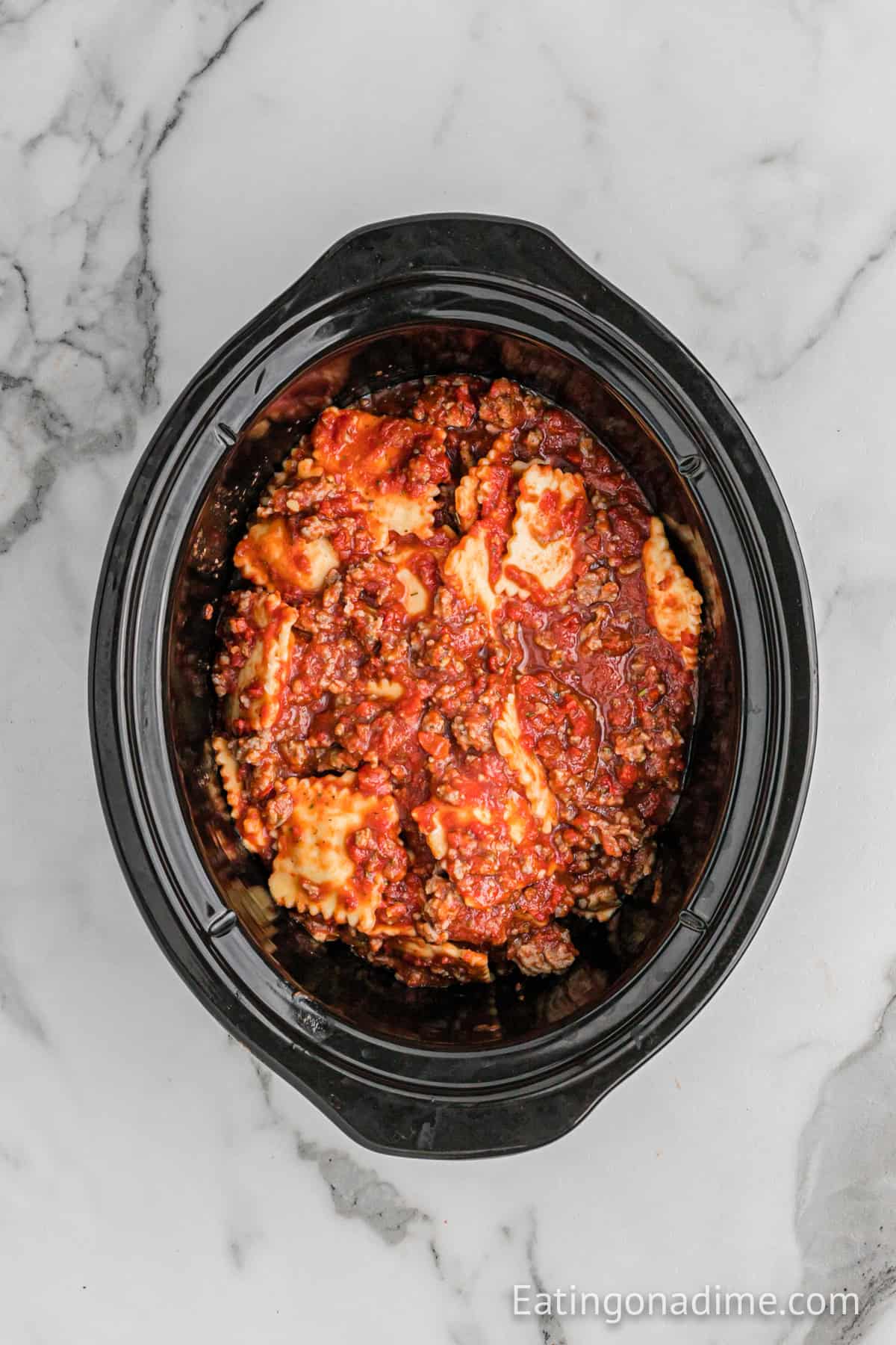 Cooked ravioli and sausage mixture in the slow cooker.