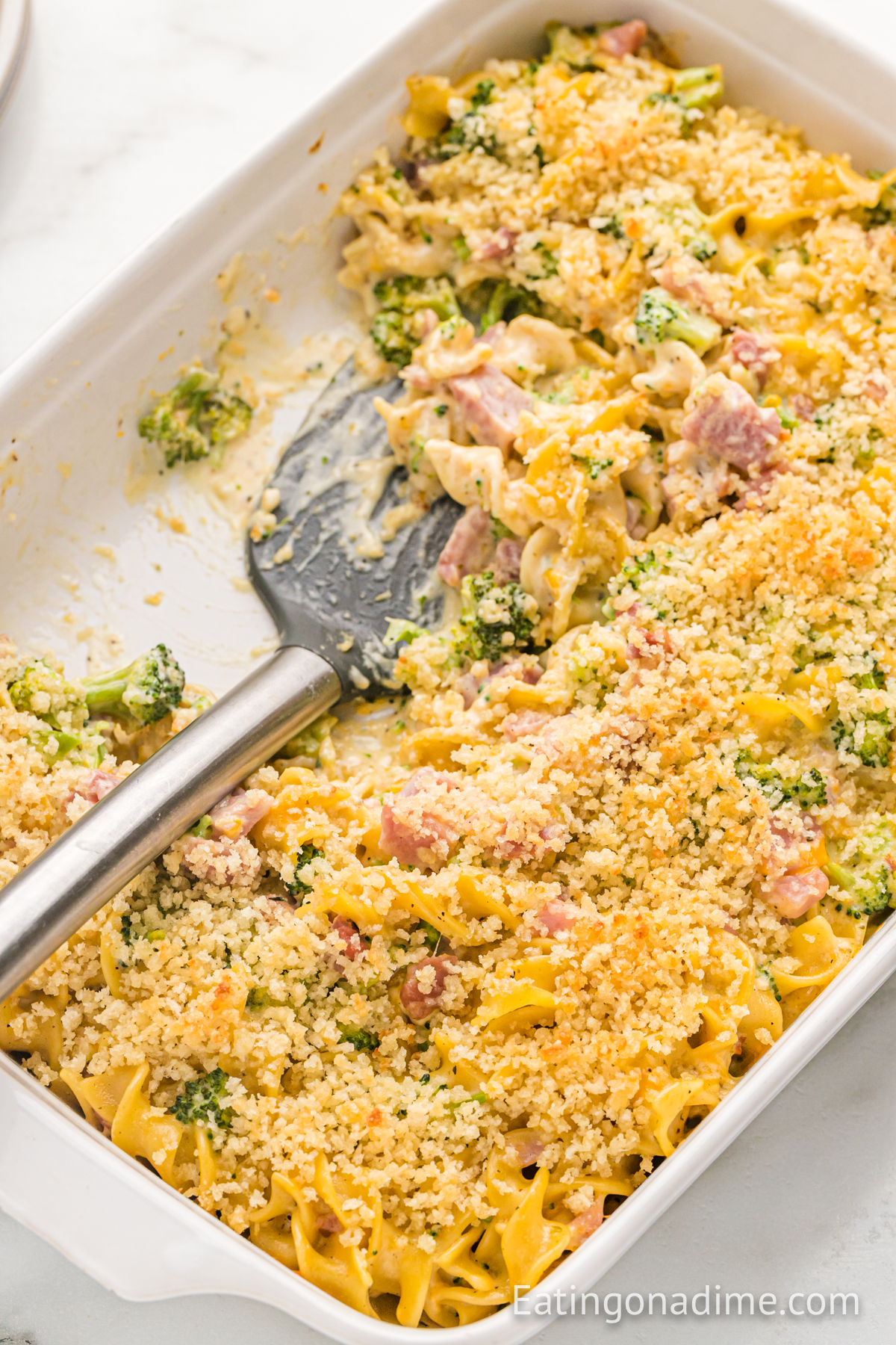 leftover ham casserole in a baking dish with a spatula