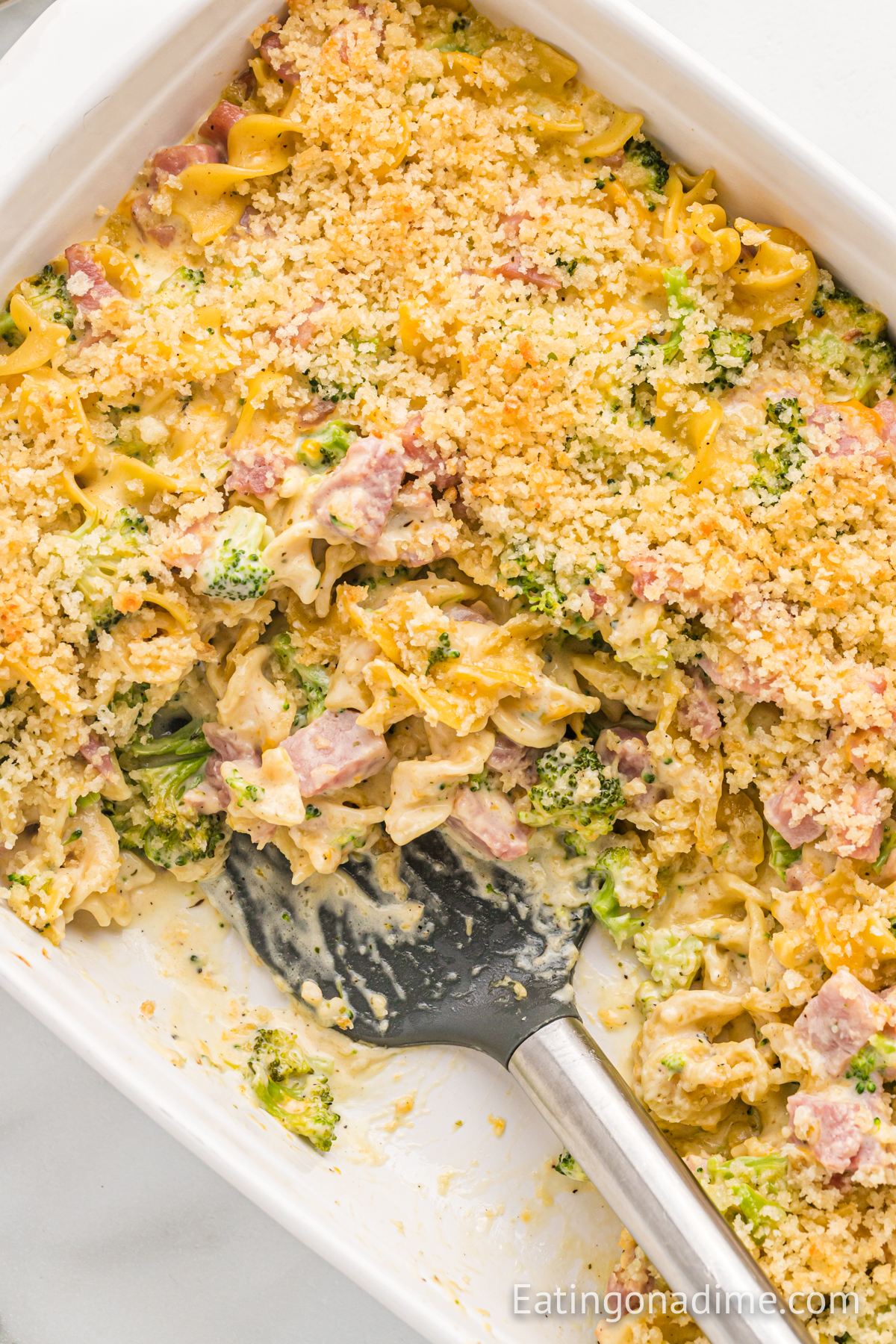 Leftover ham casserole in a baking dish with a spatula