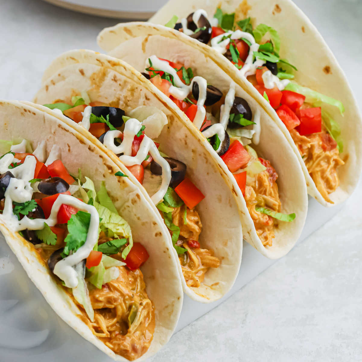 Queso Chicken Tacos lined up on a platter