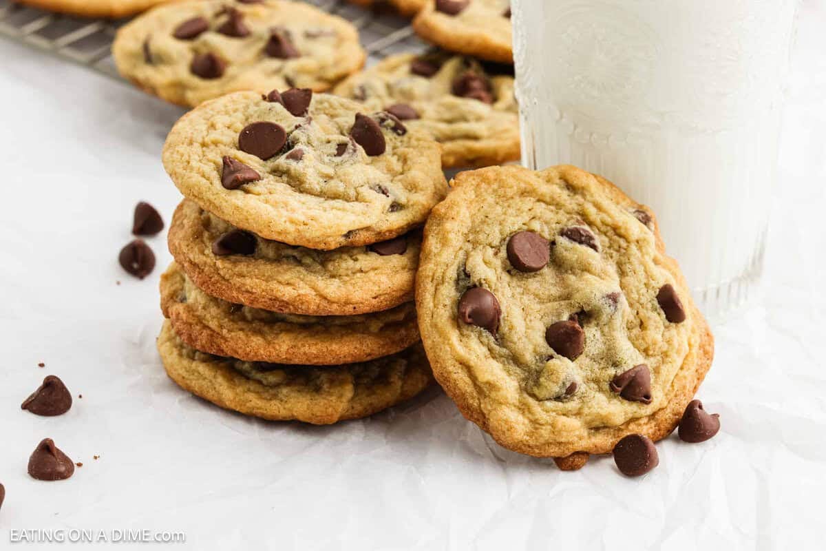 Chocolate Chip Pudding Cookies stacked with a glass of milk nearby.