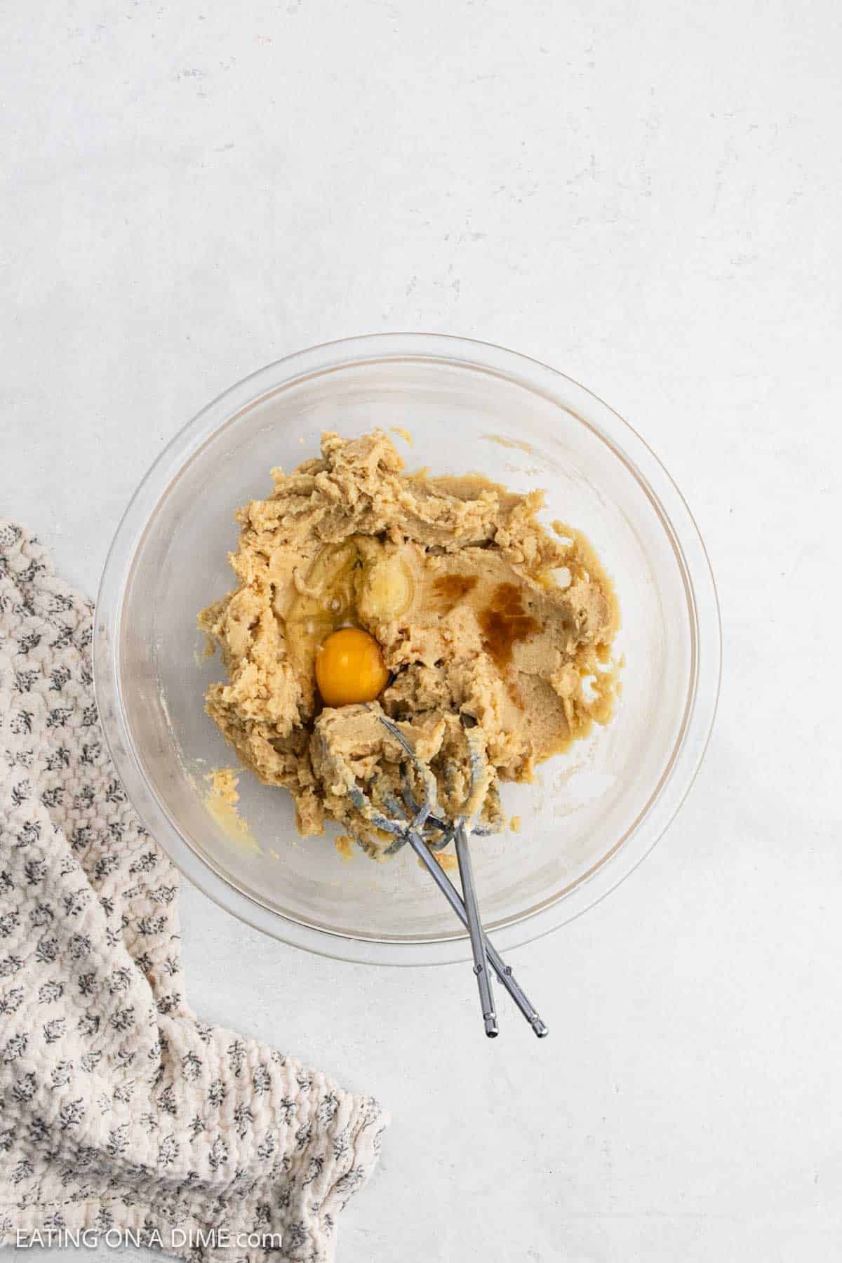 Eggs and vanilla are added to the butter mixture in a bowl.