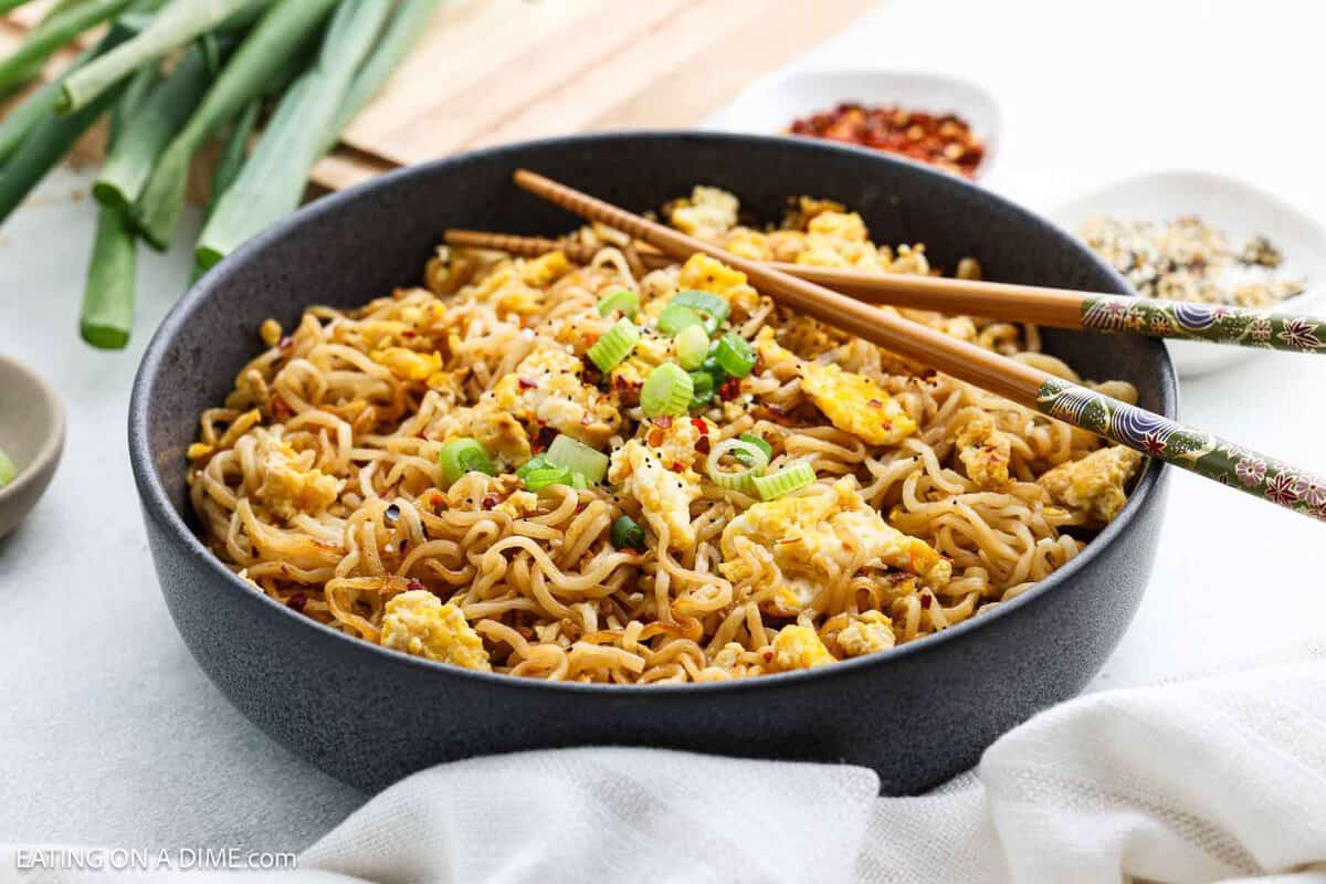 Ramen Noodles in a large bowl topped with green onions with chopsticks