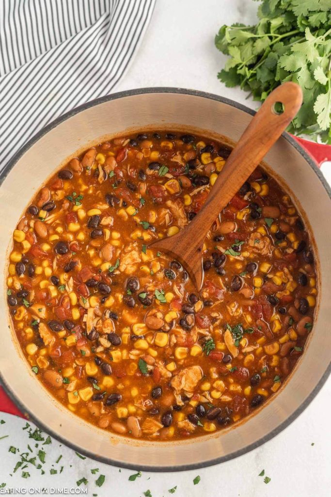 Taco Soup in a large stock pot with a wooden spoon