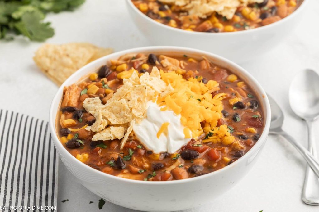 Taco Soup in a bowl topped with cheese, chips, and sour cream