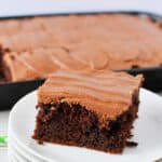 A slice of chocolate coca cola cake with frosting.