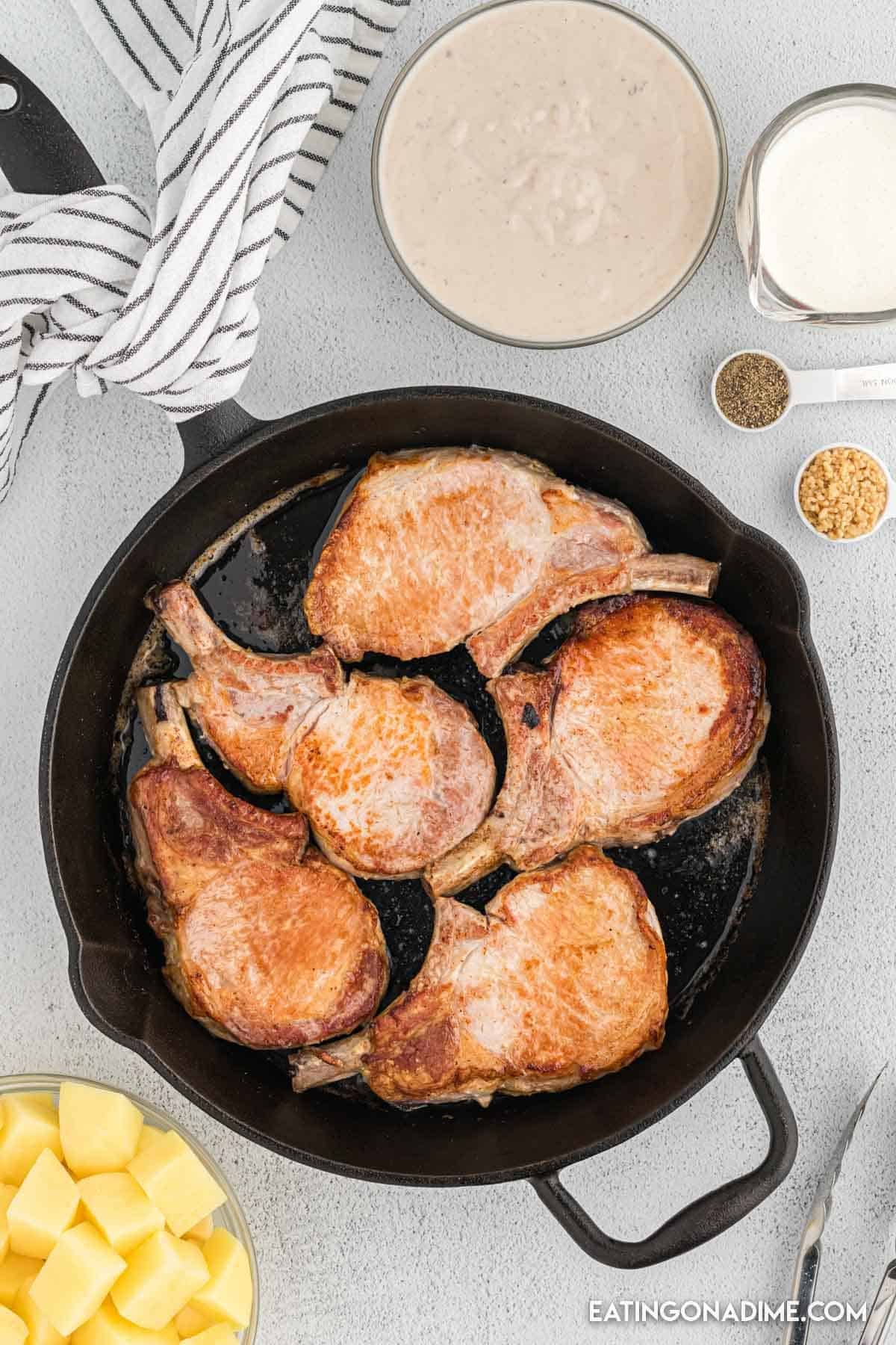 Seared pork chops in a cast iron skillet.