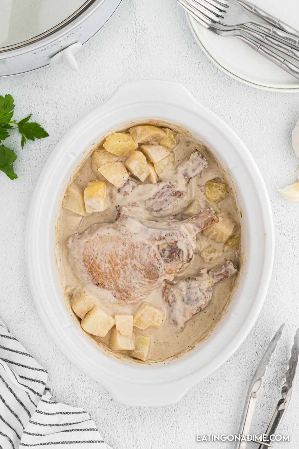 Pork chops in the slow cooker in creamy sauce with potatoes.