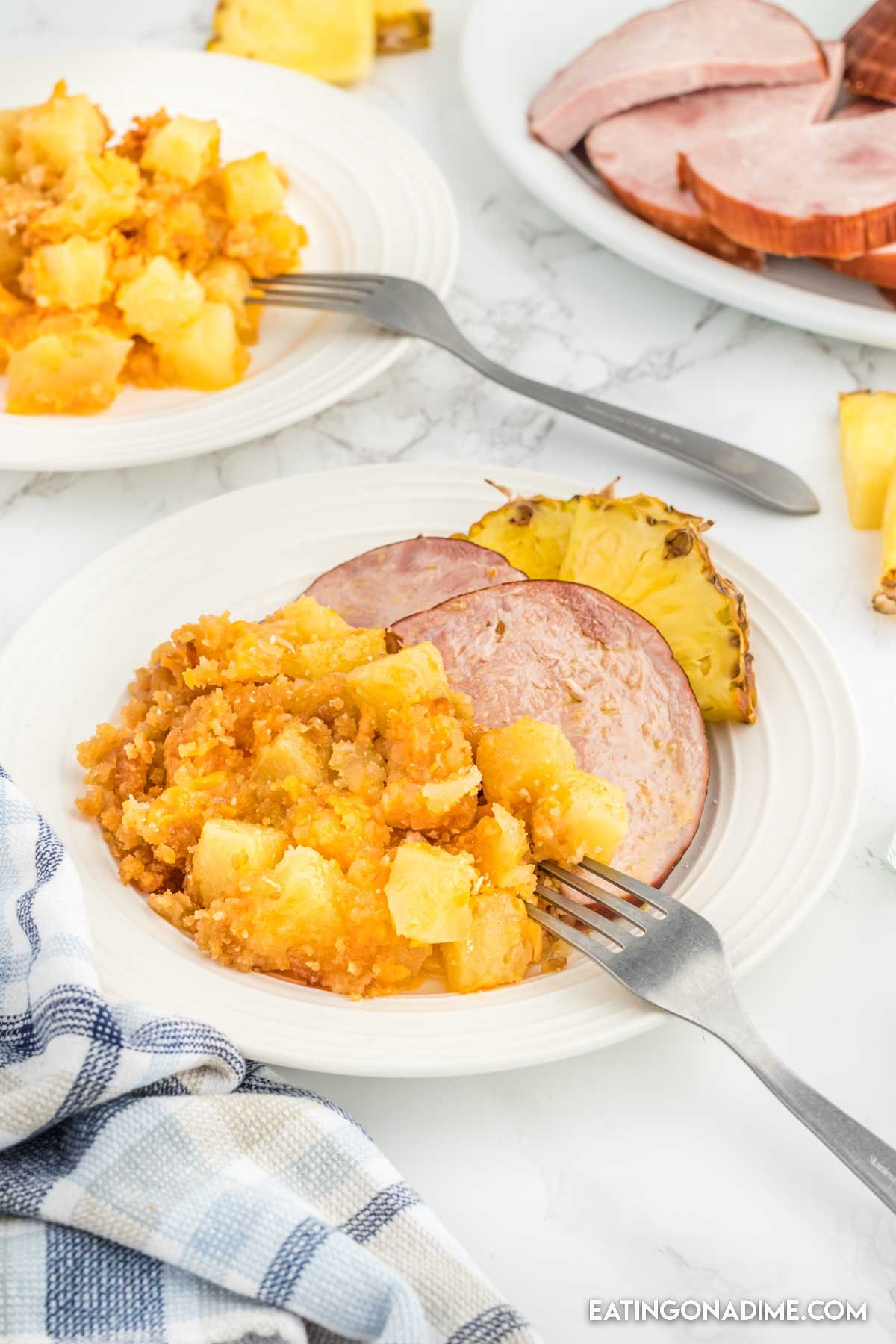 Pineapple casserole on a plate with slice ham