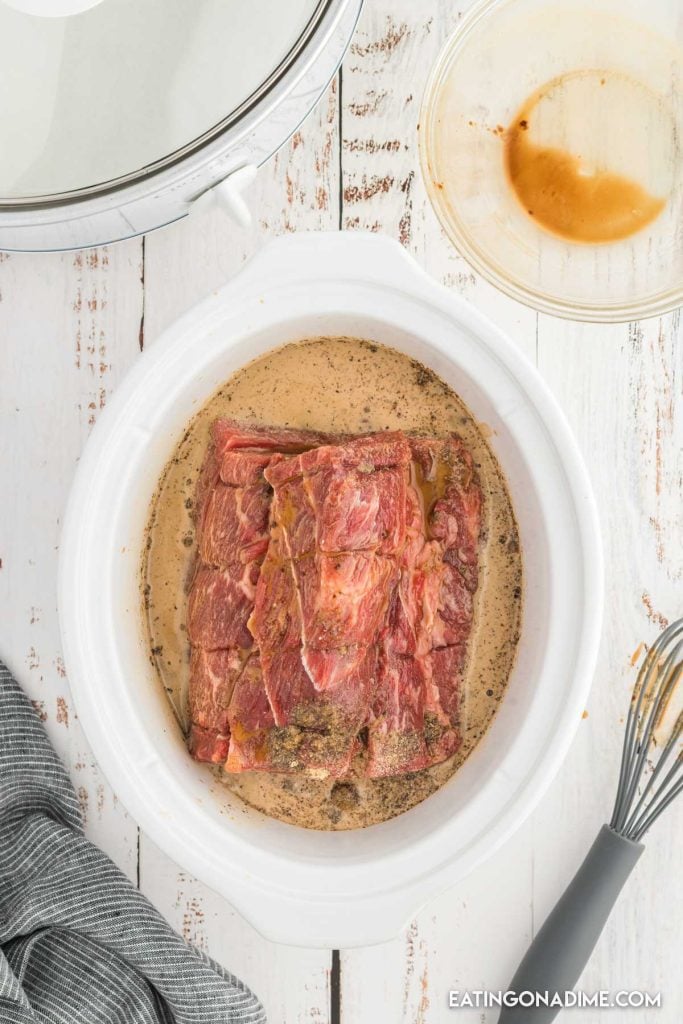 The roast beef and the ingredients in the slow cooker